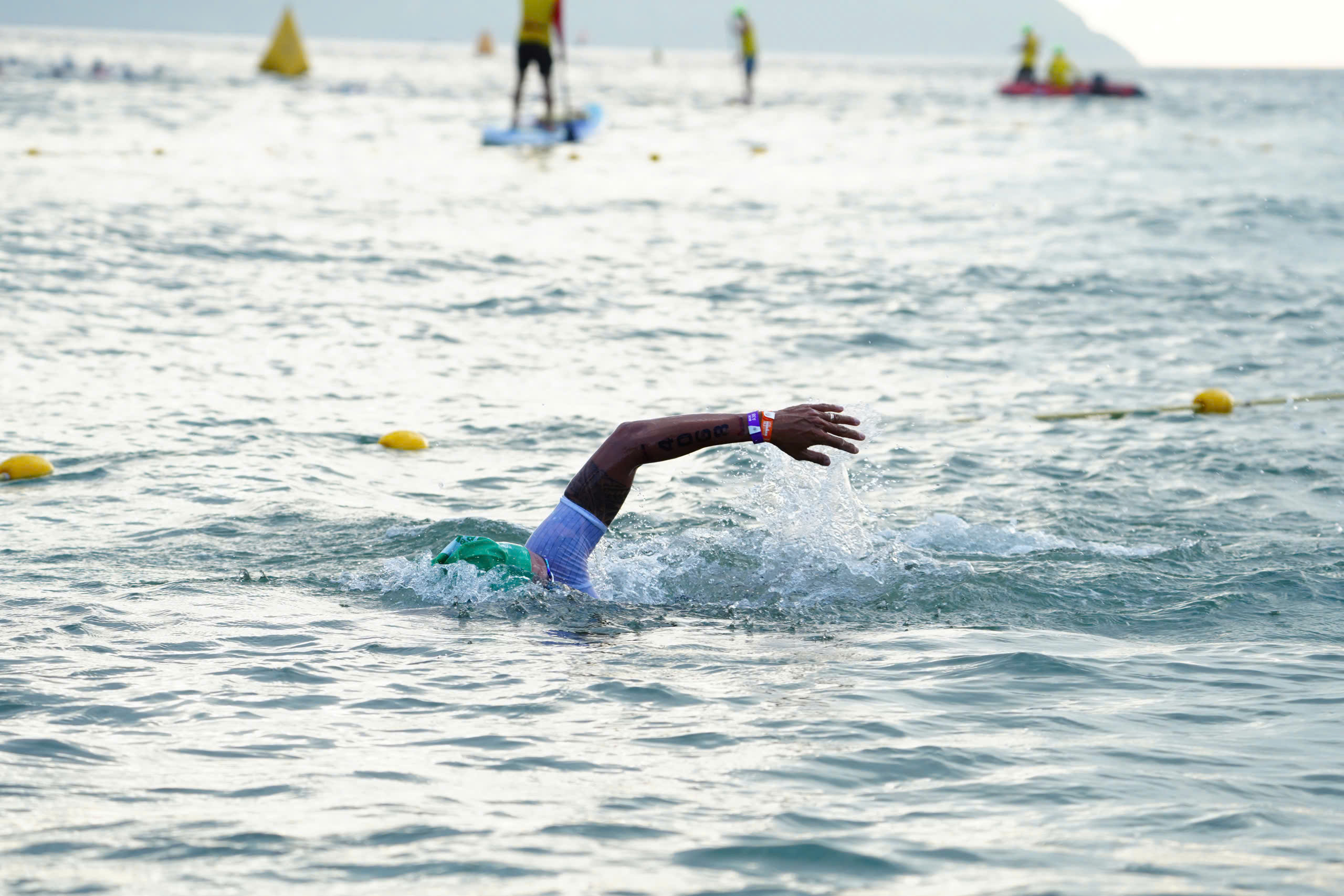 Mid-stroke in the bay — green M25-29 cap, Z3R0D suit