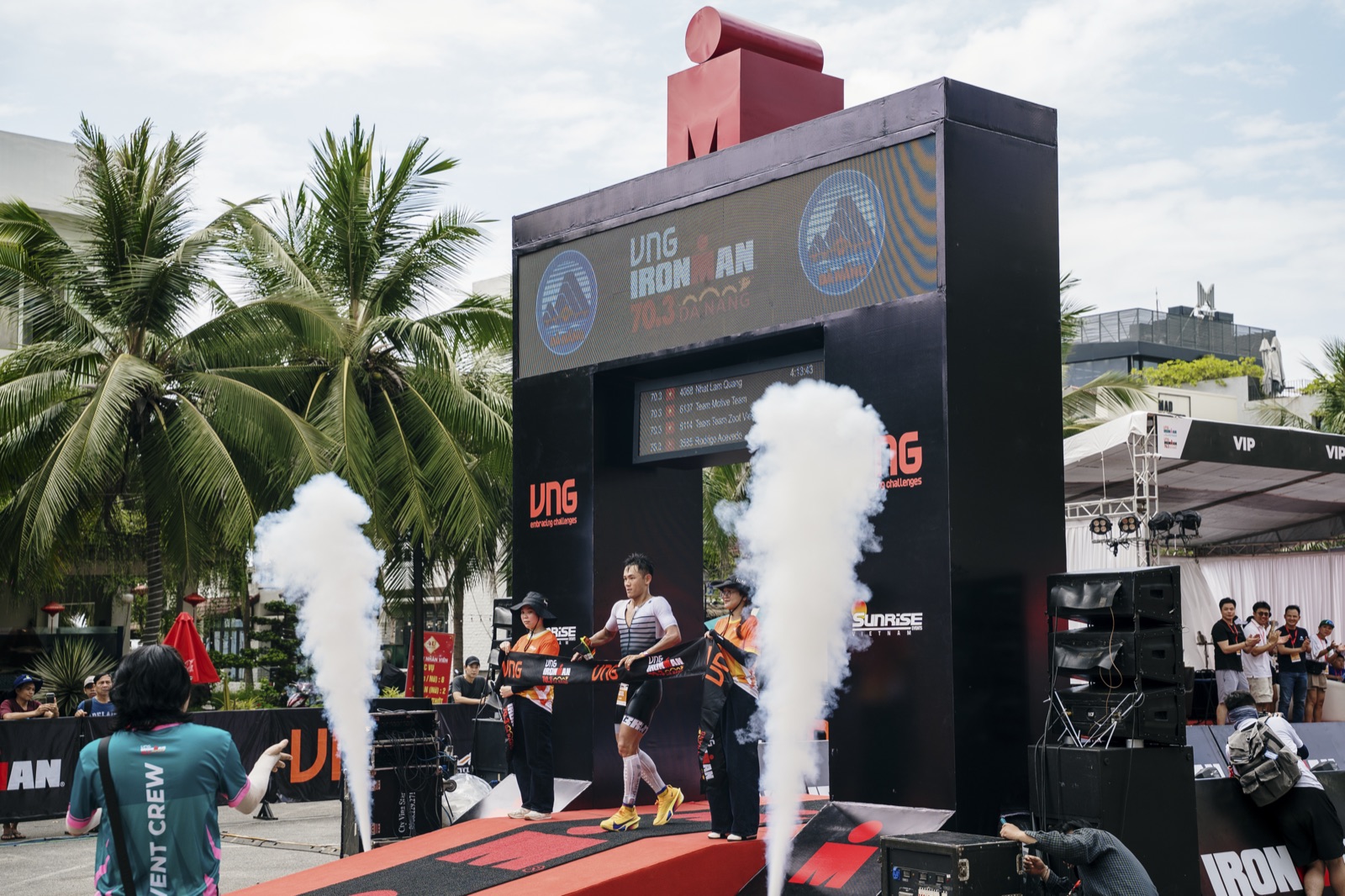Lâm Quang Nhật on the IRONMAN podium with smoke effects, Đà Nẵng